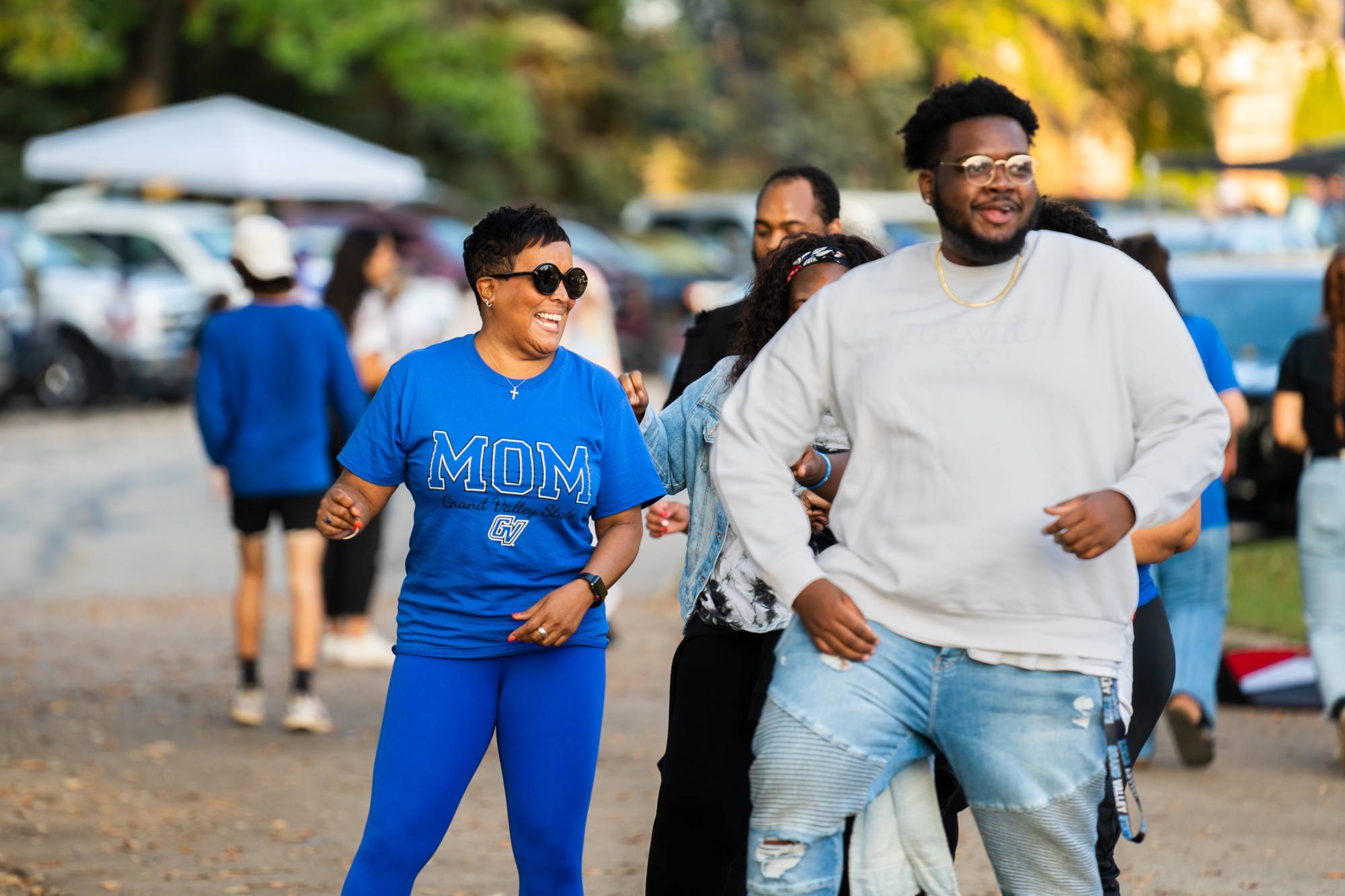 Alumni walk along a path on a campus tour led by a guide